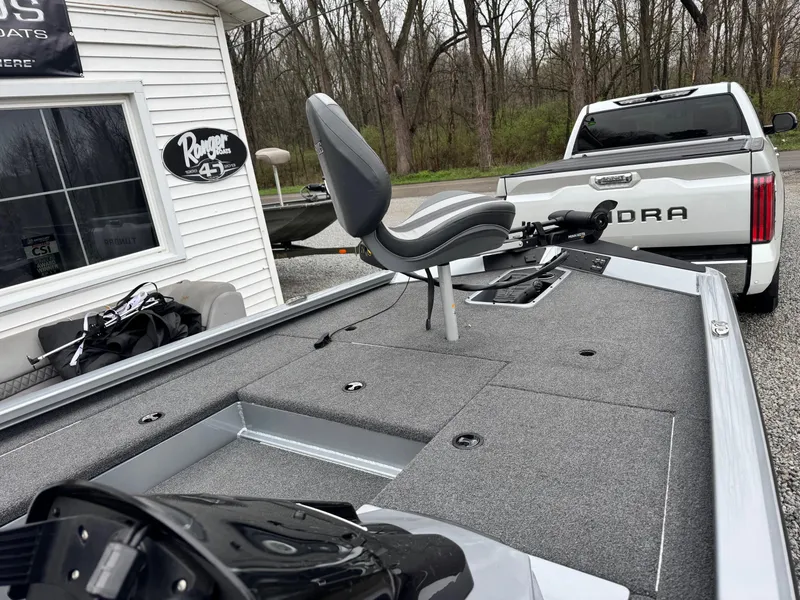 Slide: The Image of 2022 Vexus AVX181 boat with fishing seat, parked near a white building and a truck. - 6