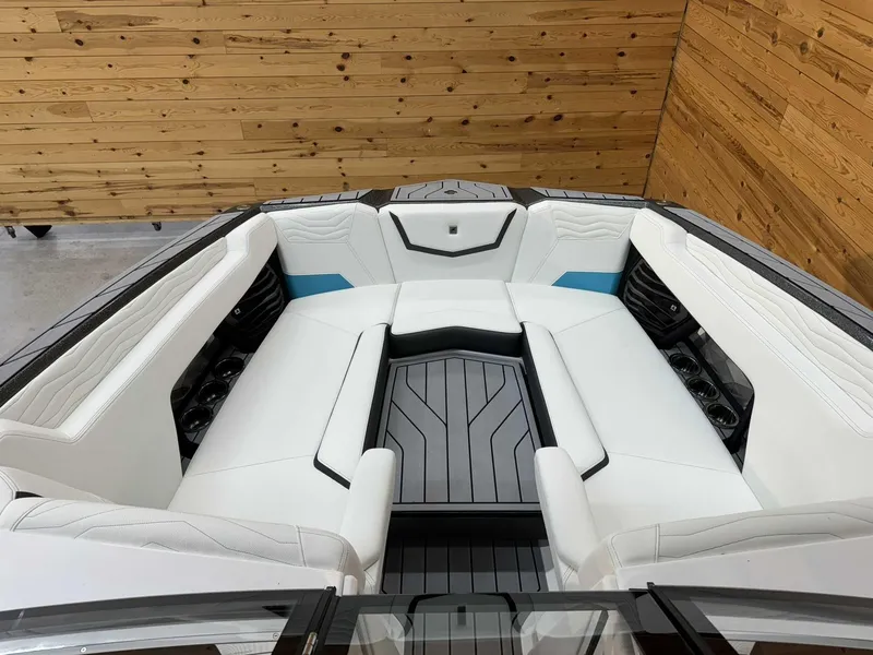 Slide: The Image of 2025 Nautique G25 boat interior with white seating and wood paneling. - 10