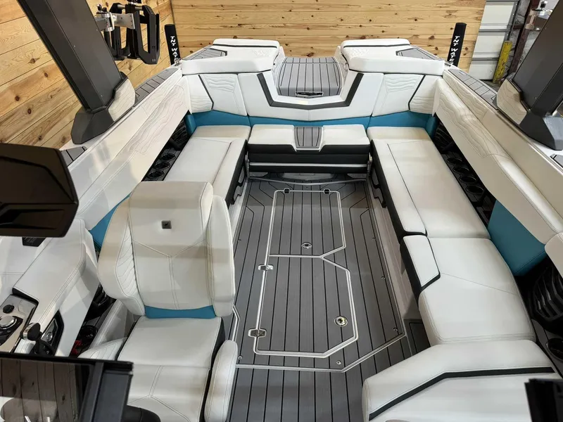 Slide: The Image of 2025 Nautique G25 boat interior with white and teal seating, modern design, and spacious layout. - 11