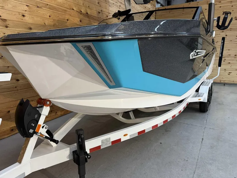 Slide: The Image of 2025 Nautique G25 boat on trailer, featuring sleek design and blue accents. - 5