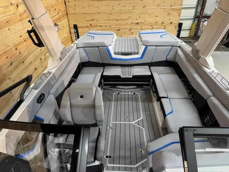 Slide: The Image of 2025 Nautique G23 boat interior with gray seating and blue accents, wooden backdrop. - 10