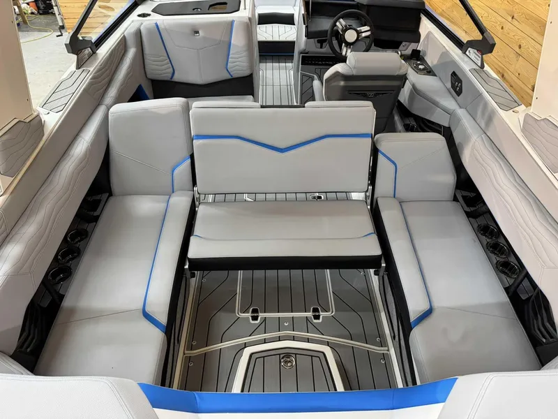 Slide: The Image of 2025 Nautique G23 boat interior with gray seating and blue accents. - 12