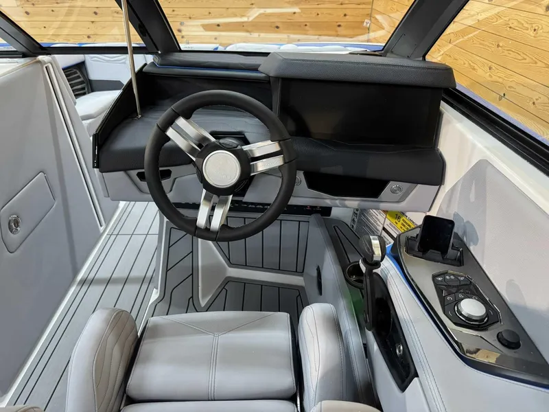 Slide: The Image of 2025 Nautique G23 boat interior with modern steering wheel and dashboard controls. - 8