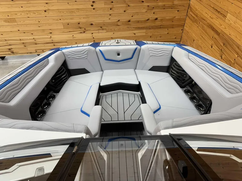 Slide: The Image of 2025 Nautique G23 boat interior with white and blue seating, wooden paneling. - 9
