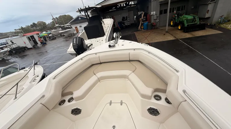 Slide: The Image of 2025 Boston Whaler 250 Outrage boat interior at a marina, showcasing seating and storage. - 4