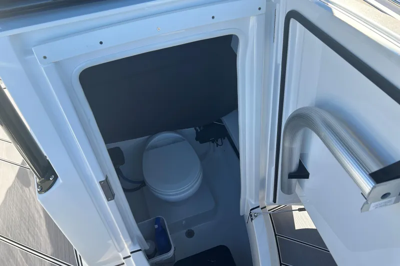 Slide: The Image of Interior view of a 2018 Blackfin 242 CC boat's compact marine toilet. - 12