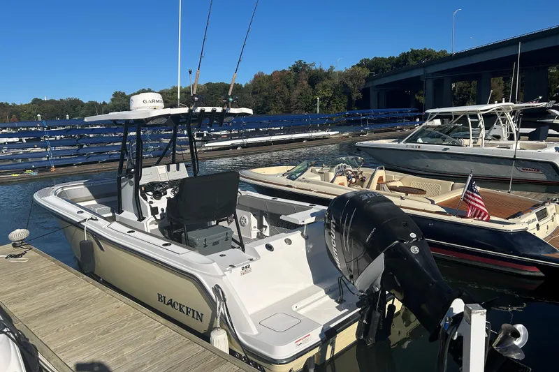 Slide: The Image of 2018 Blackfin 242 CC boat docked at marina with outboard motor. - 3