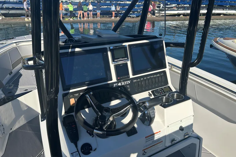 Slide: The Image of 2018 Blackfin 242 CC boat dashboard with steering wheel and navigation screens. - 5