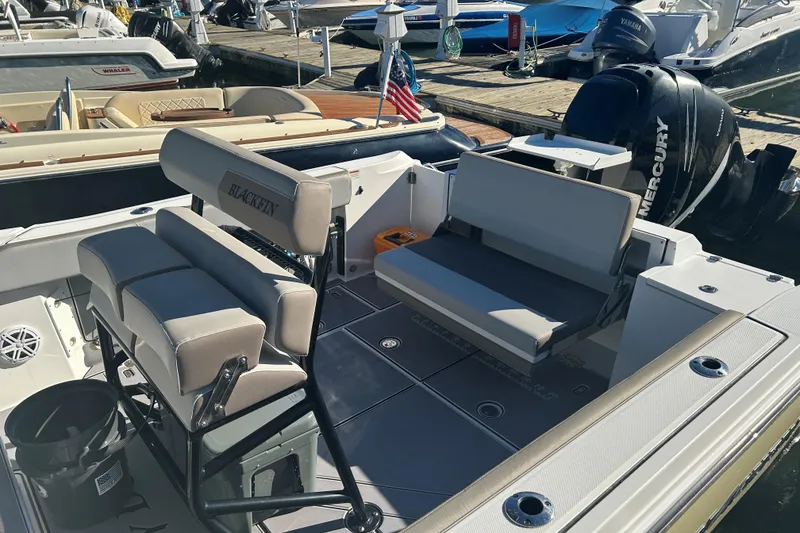 Slide: The Image of 2018 Blackfin 242 CC boat interior with seating and Mercury outboard engine at dock. - 7