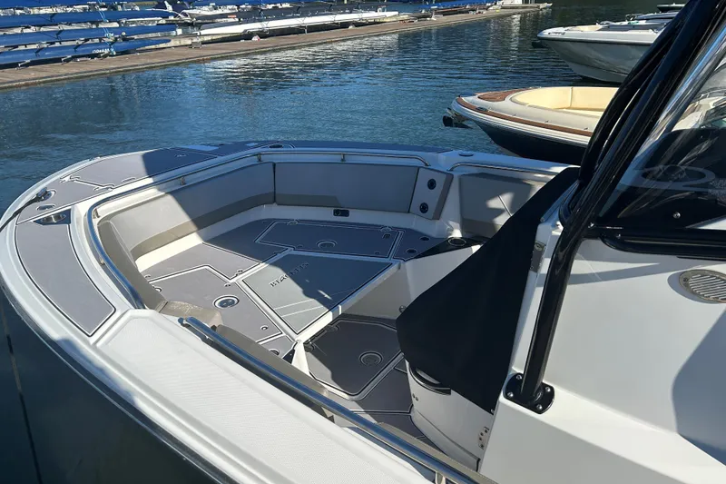 Slide: The Image of 2018 Blackfin 242 CC boat interior with spacious seating, docked by the water. - 9