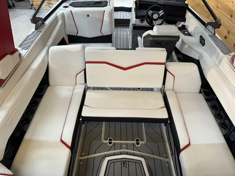Slide: The Image of 2025 Nautique G23 boat interior with white and red seating, modern design, and sleek dashboard. - 11