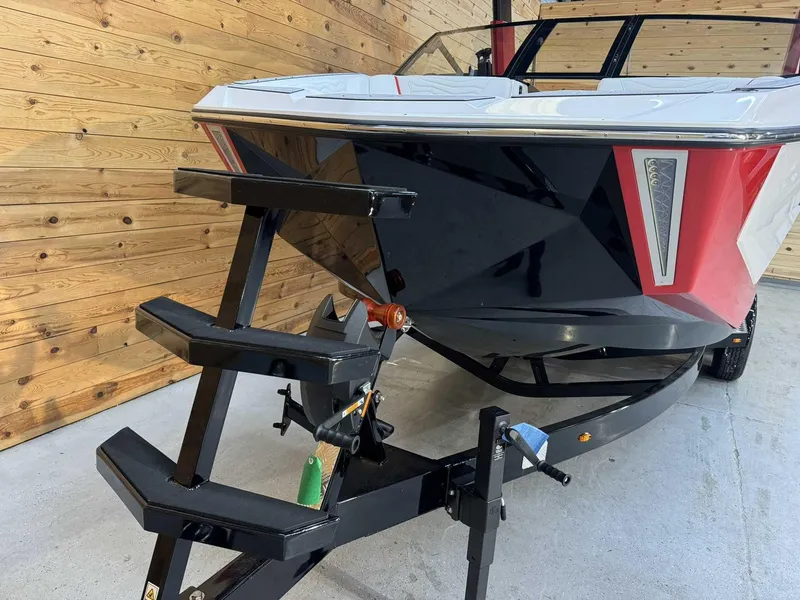 Slide: The Image of 2025 Nautique G23 boat on trailer, featuring sleek black and red design. - 5