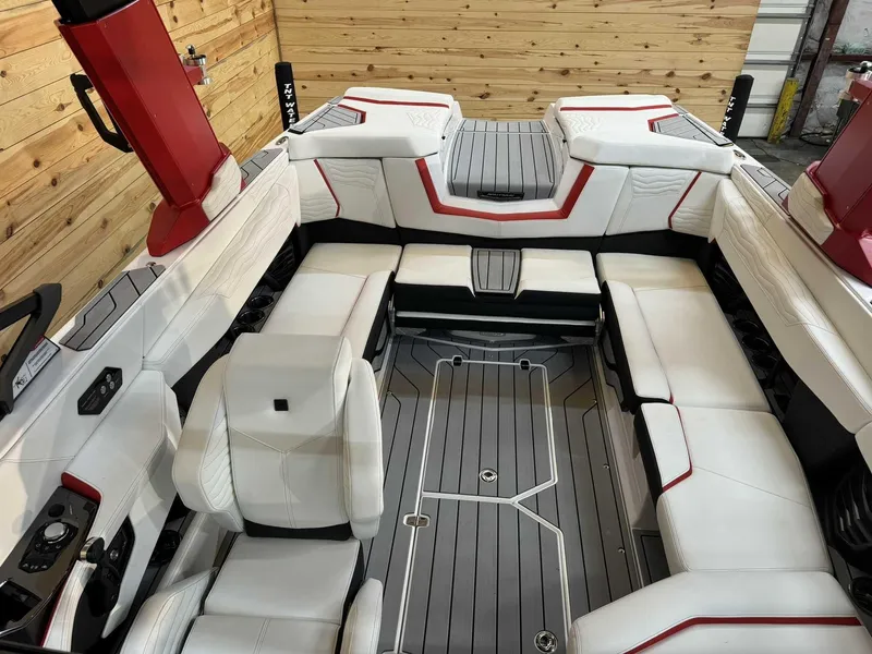 Slide: The Image of 2025 Nautique G23 boat interior with white and red seating, wooden accents, and modern design. - 9