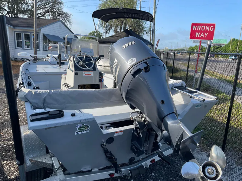 Slide: The Image of 2018 G3 Deluxe 18 boat with 90 HP motor, parked near a "Wrong Way" sign. - 3