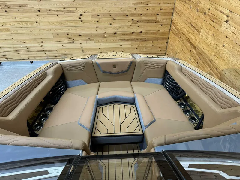 Slide: The Image of 2025 Nautique G23 boat interior with tan seating and wood accents. - 10