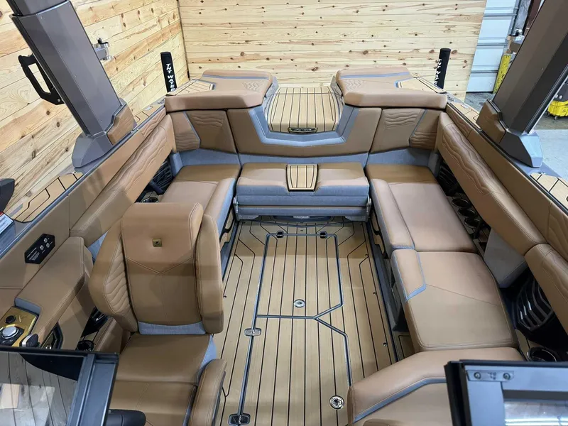 Slide: The Image of 2025 Nautique G23 boat interior with tan leather seating and wooden flooring. - 11