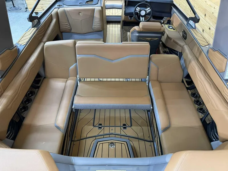 Slide: The Image of 2025 Nautique G23 boat interior with tan leather seating and modern design. - 13
