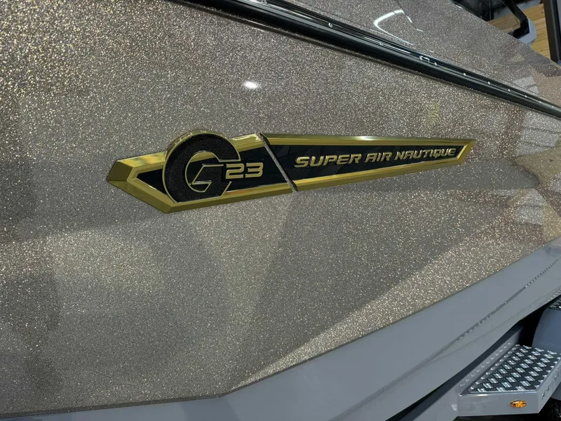 Slide: The Image of 2025 Nautique G23 Super Air Nautique boat with metallic finish and logo detail. - 5