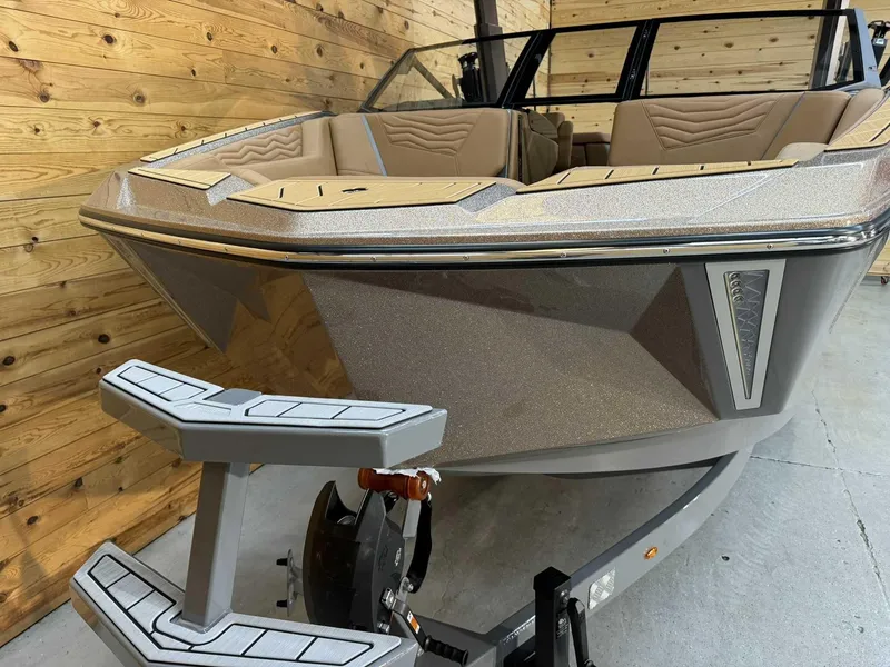 Slide: The Image of 2025 Nautique G23 boat with sleek design, beige interior, and wooden backdrop. - 7