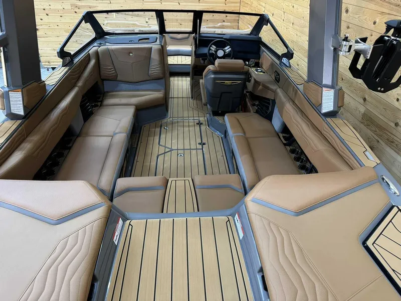 Slide: The Image of 2025 Nautique G23 boat interior with luxurious tan seating and sleek design. - 8