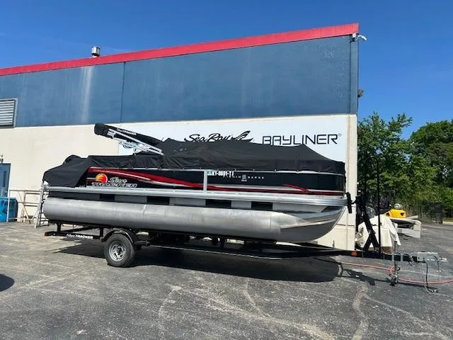 Slide: The Image of 2013 Sun Tracker Fishin' Barge 22 DLX pontoon boat on trailer, covered, outdoors. - 49