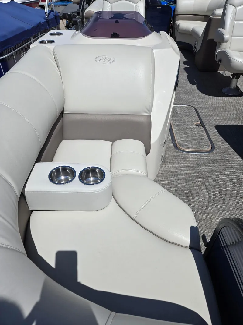 Slide: The Image of 2019 Manitou Oasis VP Tri Toon boat interior with plush seating and cup holders. - 19