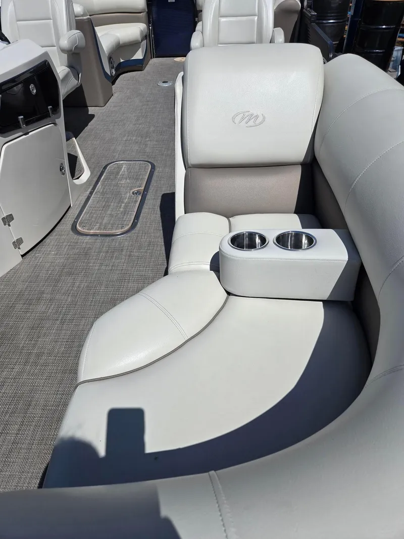 Slide: The Image of 2019 Manitou Oasis VP Tri Toon interior with plush seating and cup holders. - 20