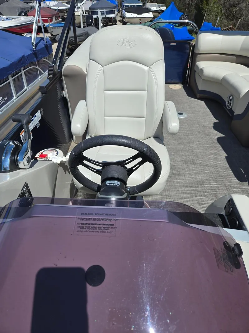 Slide: The Image of 2019 Manitou Oasis VP Tri Toon boat interior with steering wheel and seating. - 21