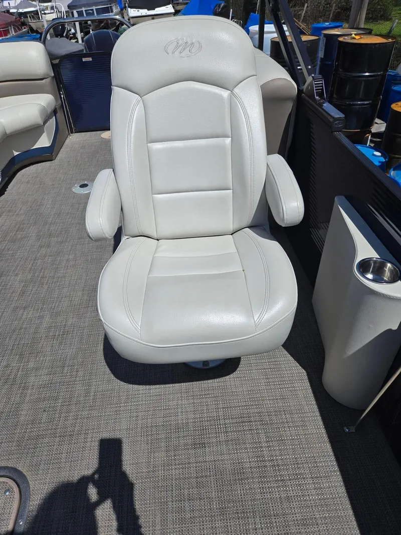 Slide: The Image of 2019 Manitou Oasis VP Tri Toon boat seat, white leather, on deck with cup holder. - 22