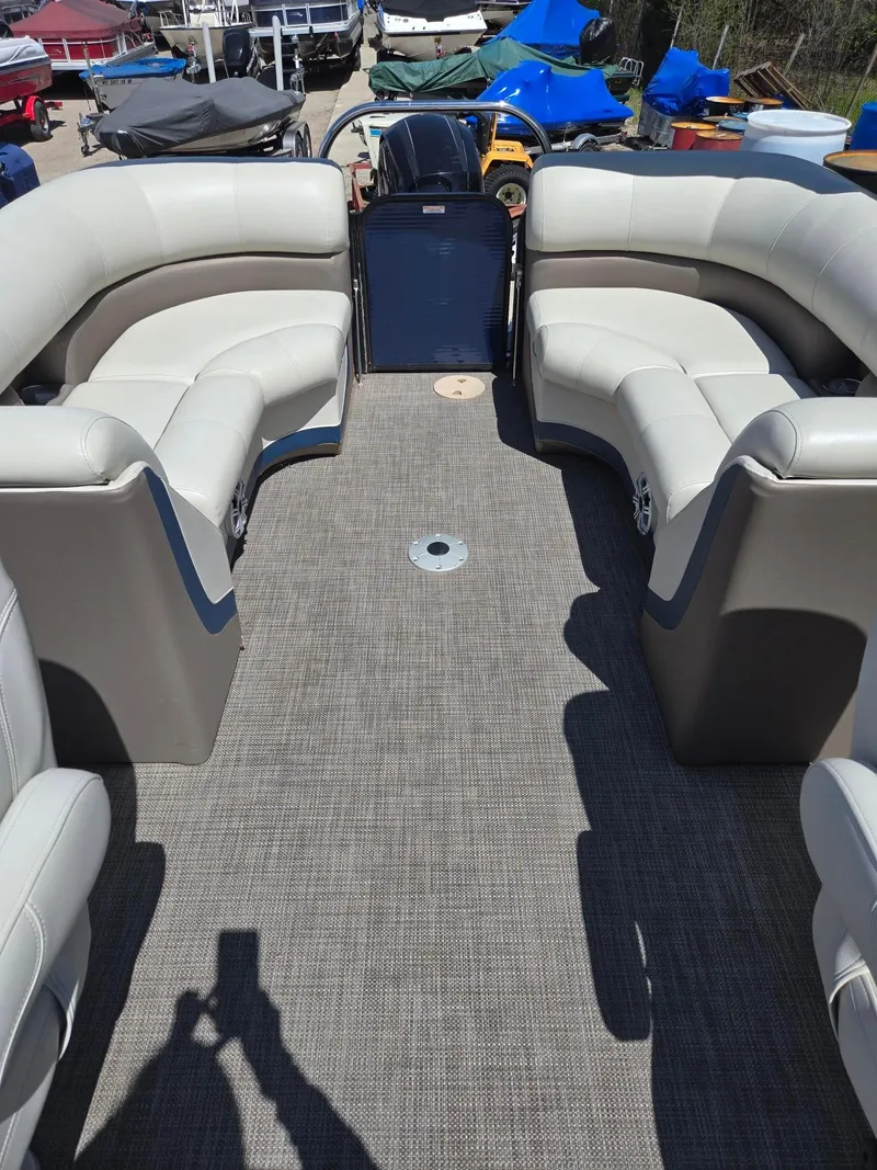 Slide: The Image of 2019 Manitou Oasis VP Tri Toon boat interior with plush seating and spacious deck. - 23