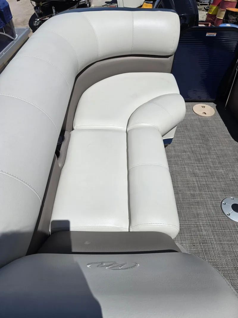 Slide: The Image of 2019 Manitou Oasis VP Tri Toon boat with white leather seating and gray flooring. - 24