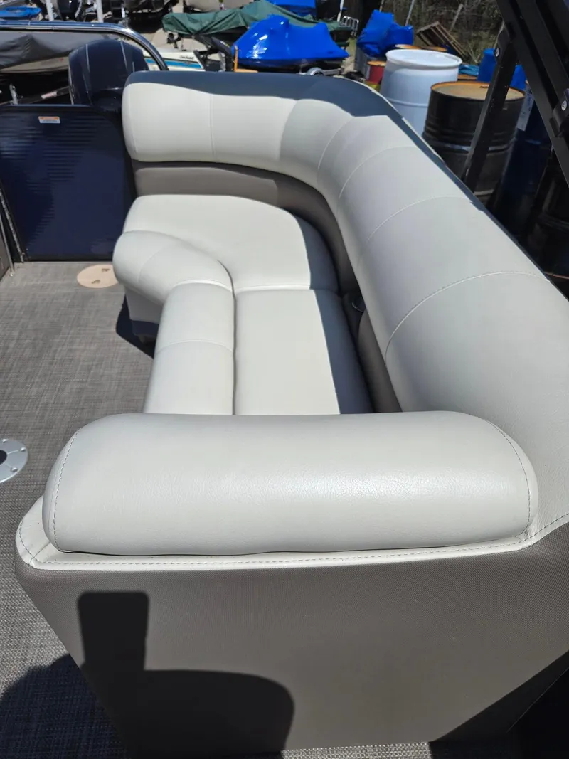 Slide: The Image of 2019 Manitou Oasis VP Tri Toon boat with beige seating and carpeted floor. - 25