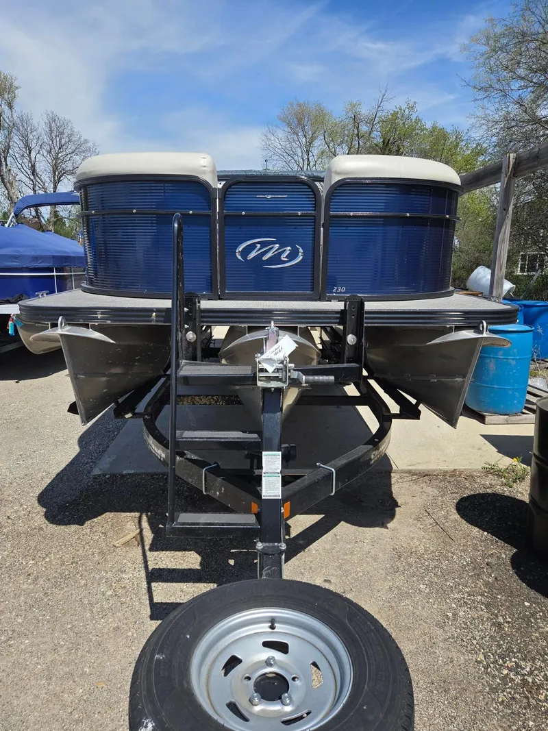 Slide: The Image of 2019 Manitou Oasis VP Tri Toon boat on trailer, front view, outdoors. - 3