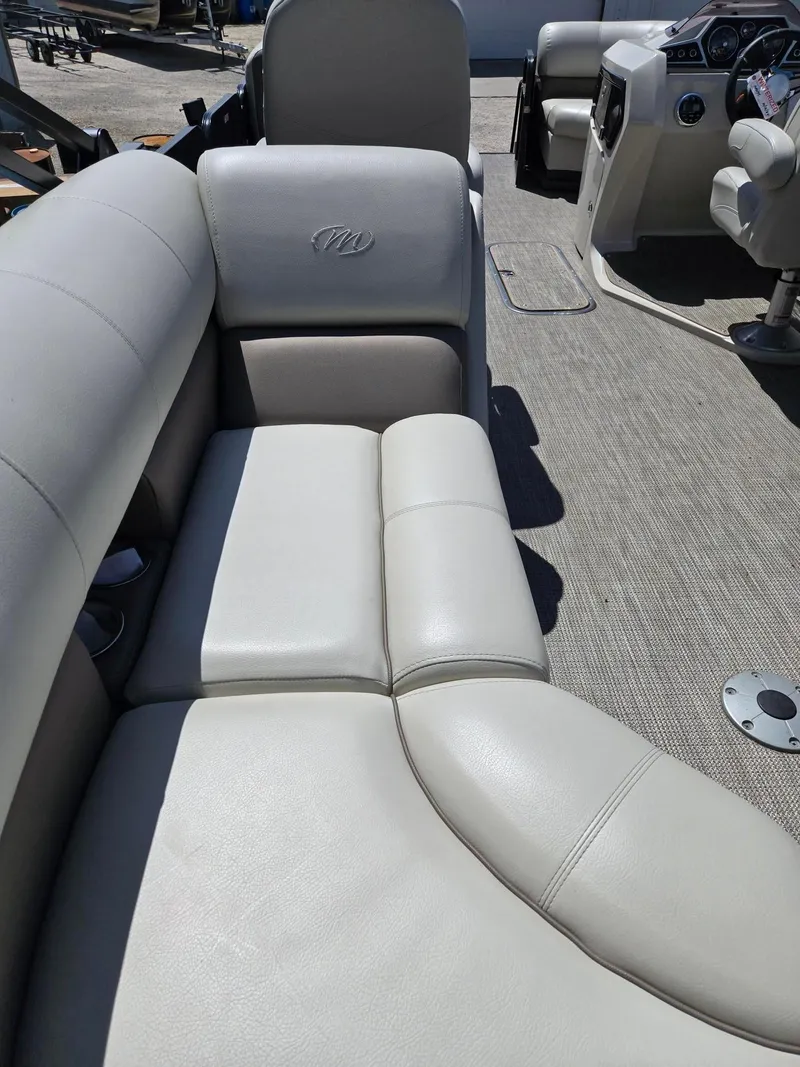 Slide: The Image of 2019 Manitou Oasis VP Tri Toon boat interior with plush seating and modern dashboard. - 6