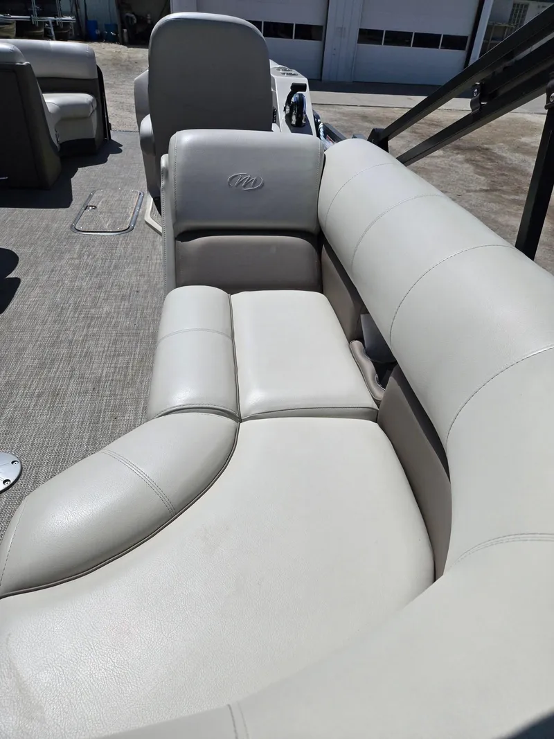 Slide: The Image of 2019 Manitou Oasis VP Tri Toon boat with luxurious beige seating. - 7