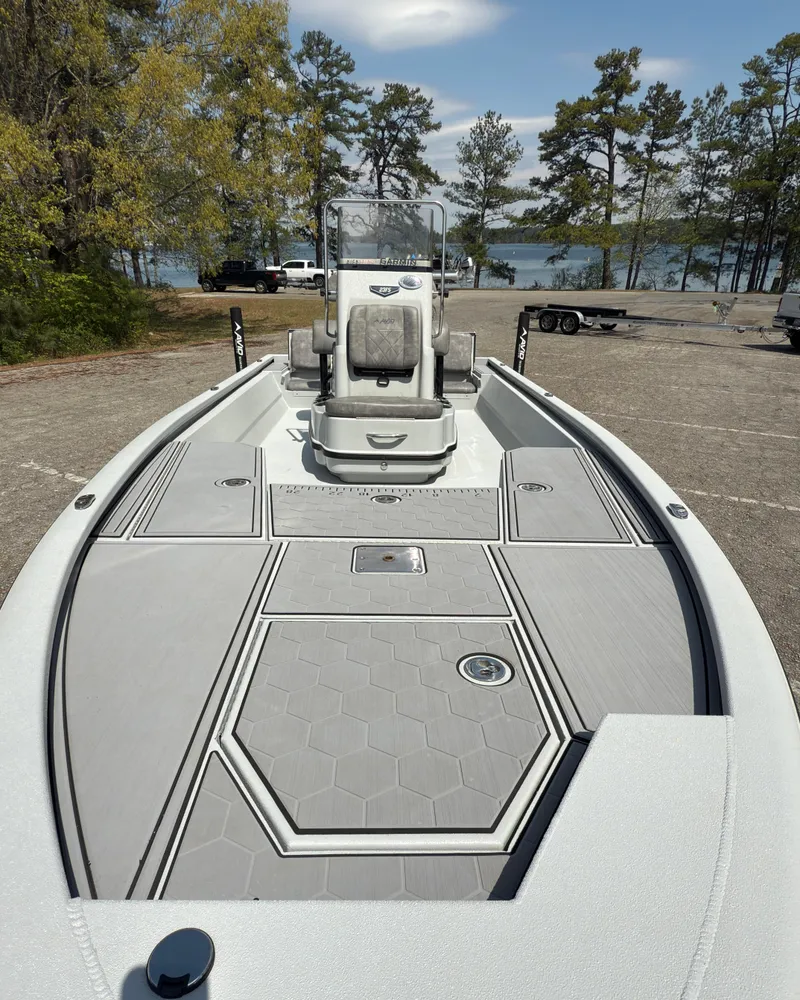 Slide: The Image of 2023 Avid 23 FS boat with sleek deck design, parked near a scenic lake. - 9