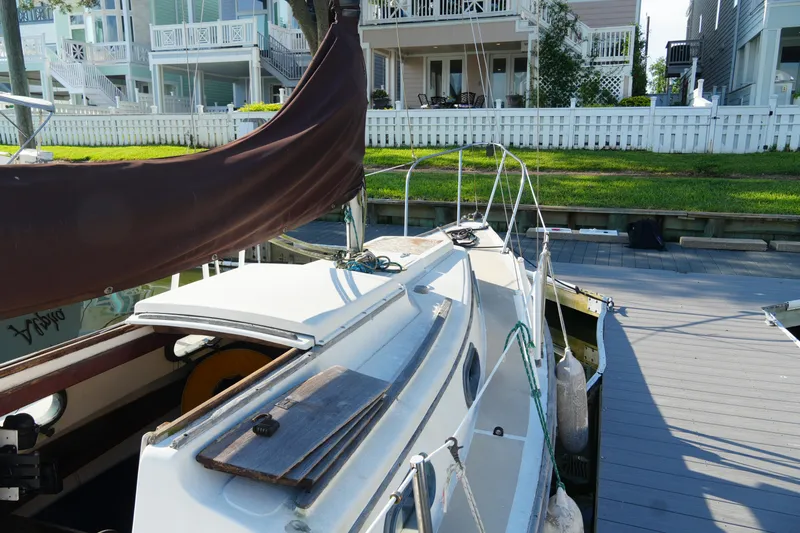 Slide: The Image of 1982 Cape Dory 25 sailboat docked near waterfront homes, sunny day. - 2