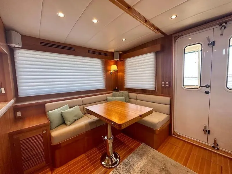 Slide: The Image of 2019 Kadey-Krogen 44AE yacht interior with cozy seating and wooden table. - 12