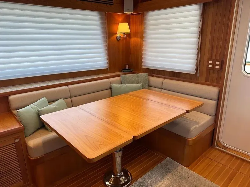 Slide: The Image of 2019 Kadey-Krogen 44AE yacht interior with wooden dining table and cushioned seating. - 13
