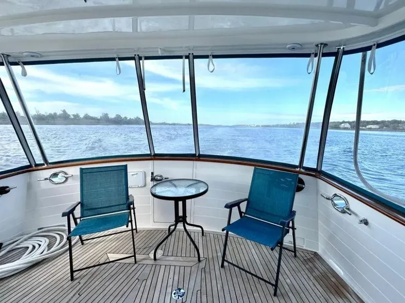 Slide: The Image of Kadey-Krogen 44AE 2019 yacht deck with chairs and table overlooking serene water. - 4