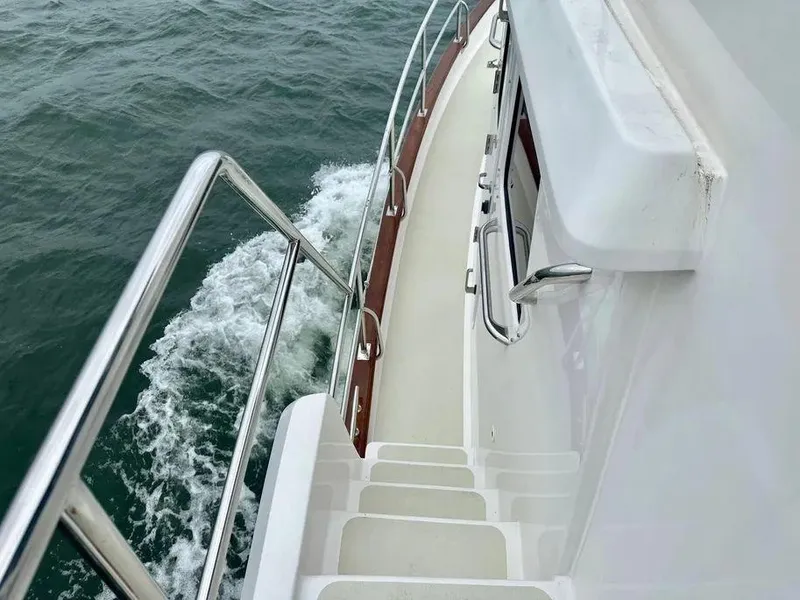 Slide: The Image of 2019 Kadey-Krogen 44AE yacht deck with railing, cruising on open water. - 44