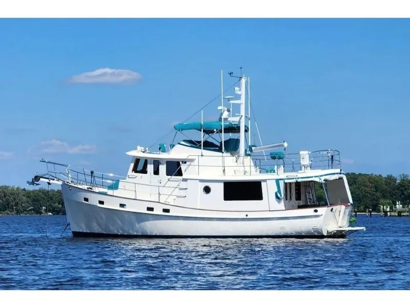 Slide: The Image of 2019 Kadey-Krogen 44AE yacht on calm water under clear blue sky. - 8