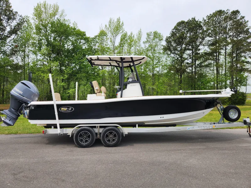 The Image of 2017 Sea Hunt BX 25 BR boat on trailer, black hull, outboard motor, parked outdoors. - 0