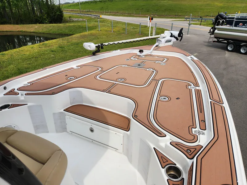 Slide: The Image of 2017 Sea Hunt BX 25 BR boat deck with brown and white design, parked near a pond. - 13