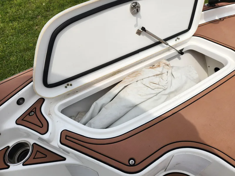 Slide: The Image of Open storage compartment on 2017 Sea Hunt BX 25 BR boat with white cover inside. - 14