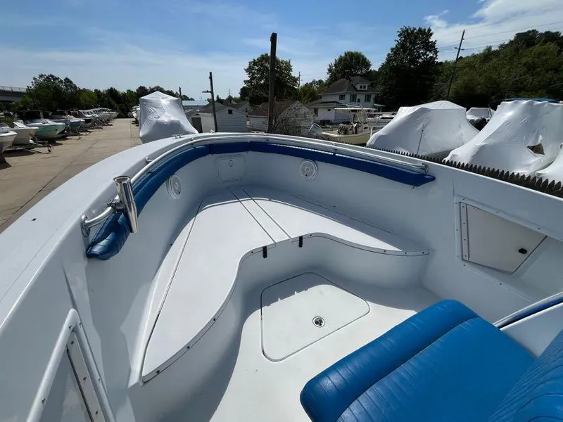 Slide: The Image of 2000 Hydra-Sports 2796 Vector boat with blue seating, docked outdoors under clear skies. - 11