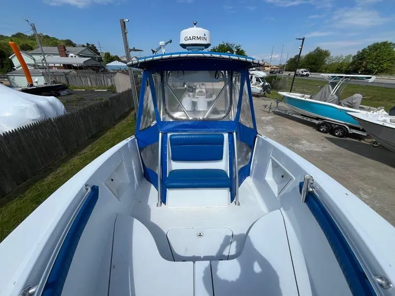 Slide: The Image of 2000 Hydra-Sports 2796 Vector boat with blue seating and Garmin equipment, docked outdoors. - 12