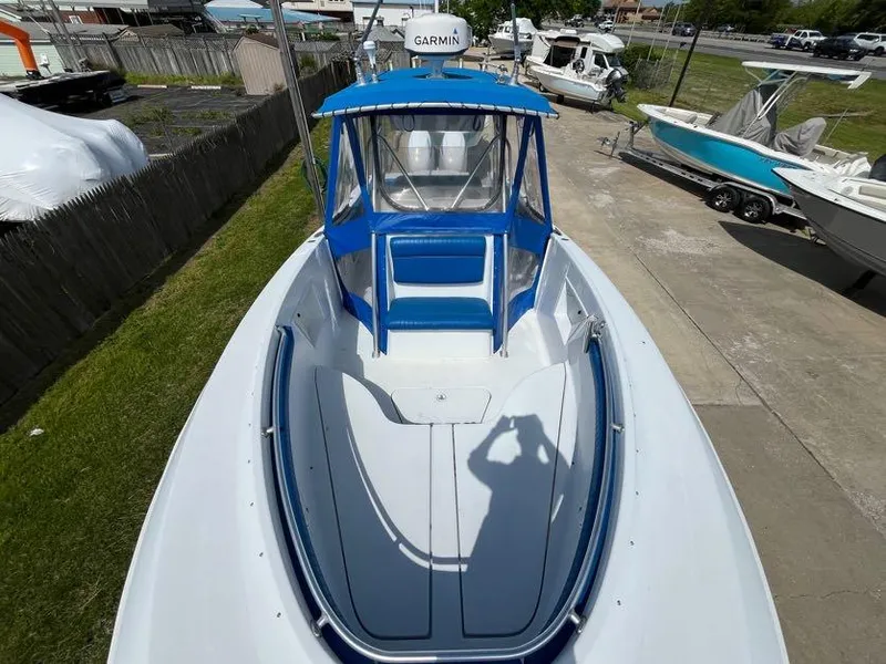 Slide: The Image of 2000 Hydra-Sports 2796 Vector boat with blue canopy and Garmin equipment, docked outdoors. - 13