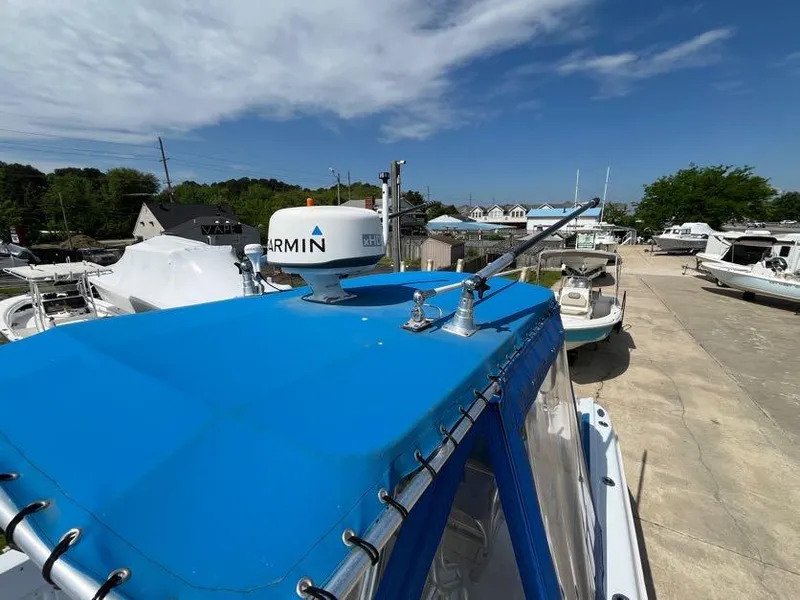 Slide: The Image of 2000 Hydra-Sports 2796 Vector boat with blue canopy and Garmin radar, docked under clear sky. - 14