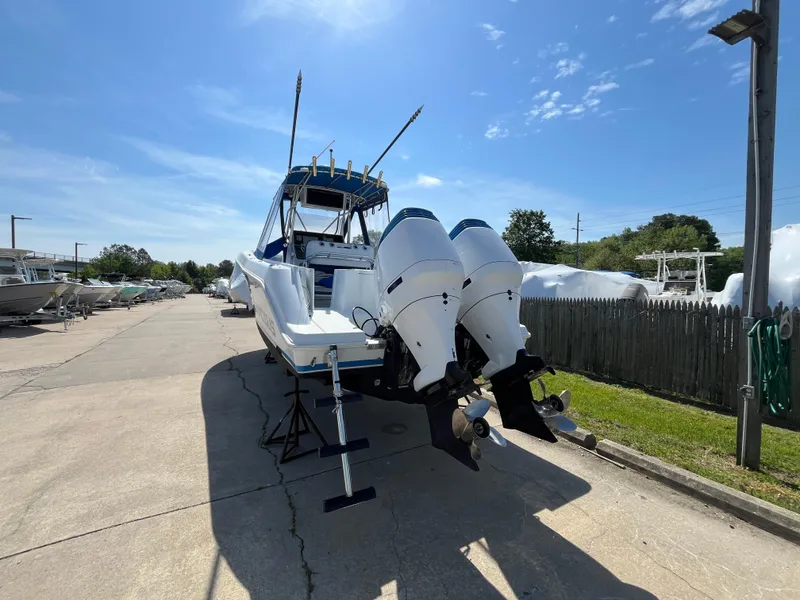 Slide: The Image of 2000 Hydra-Sports 2796 Vector boat with dual outboard motors on a sunny day. - 4